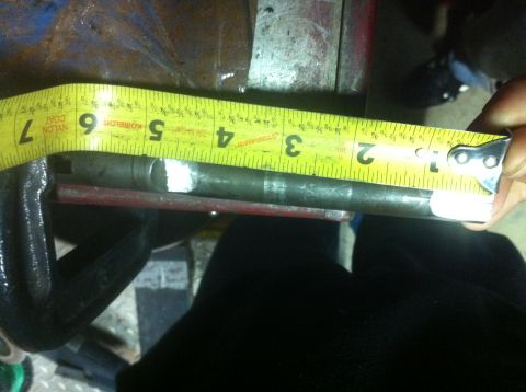 1989 Ford Bronco - A metal rod is measured with a tape measure, indicating its length in inches.