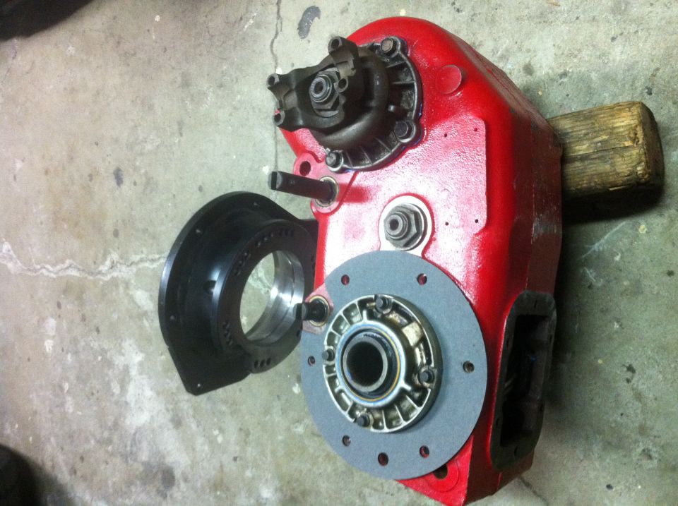 Red transfer case housing with a black adapter plate and a gasket with a bearing assembly