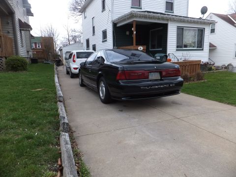 1970 Ford Ranchero - Rear view of a black Ford Thunderbird SC in a driveway with a white SUV behind it.