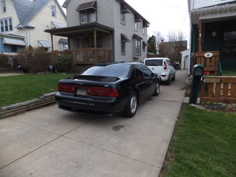 1970 Ford Ranchero - Rear view of a black Ford Thunderbird SC with a white SUV behind it in a residential driveway.
