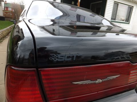 1970 Ford Ranchero - Black car's rear with taillight and trunk badging. The bird emblem is visible.