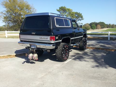 1986 Ford Bronco - This lifted 1980 Chevrolet K5 Blazer features custom wheels and novelty items hanging from the rear bumper.