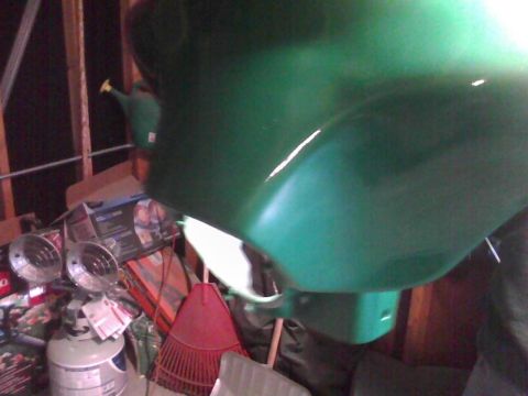 2003 Ford Crown Victoria - A green painted car fender is stored in a garage with various items around it.