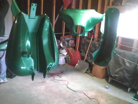 2003 Ford Crown Victoria - Several green motorcycle fairing pieces are shown in a garage, possibly after being painted.
