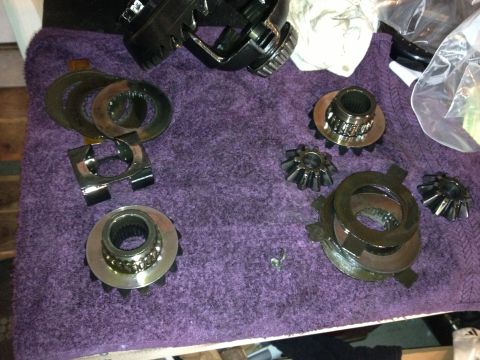 1990 Ford Mustang - Differential components are disassembled and arranged on a textured surface.