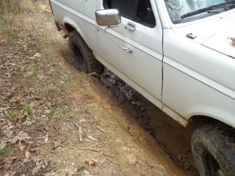 1990 Ford Bronco - This vehicle appears to be stuck in the mud on a dirt trail.