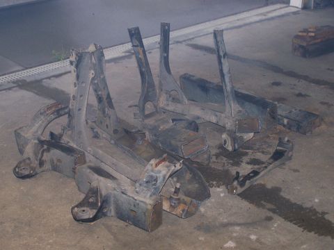 1988 Suzuki Samurai - These are parts of a vehicle frame, possibly for a Suzuki Samurai, lying on a concrete surface.