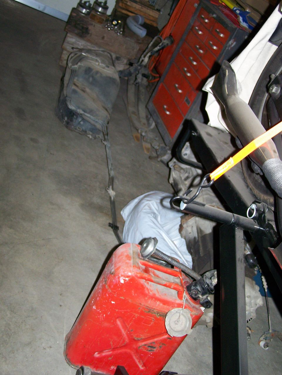 Fuel tank and red gas can on garage floor