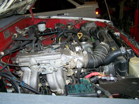 1988 Suzuki Samurai - Close-up view of a vehicle's engine compartment, showing the fuel injection system and battery terminals.