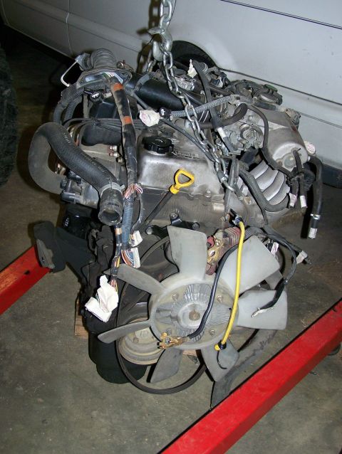 1988 Suzuki Samurai - Engine assembly, likely a Toyota 2.7L swap, is hoisted for installation or removal.
