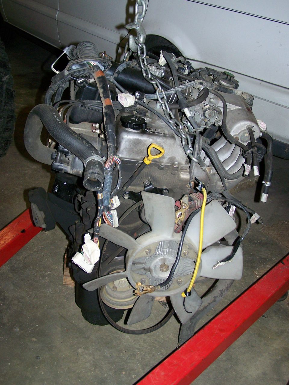 Engine assembly with fan and chains, suspended on a red engine hoist