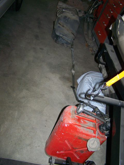 1988 Suzuki Samurai - A red gas can and a vehicle fuel tank are shown on a concrete floor.