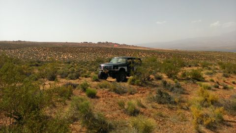 1994 Ford Bronco - Ford Bronco parked in a desert landscape with sparse vegetation and distant hills.