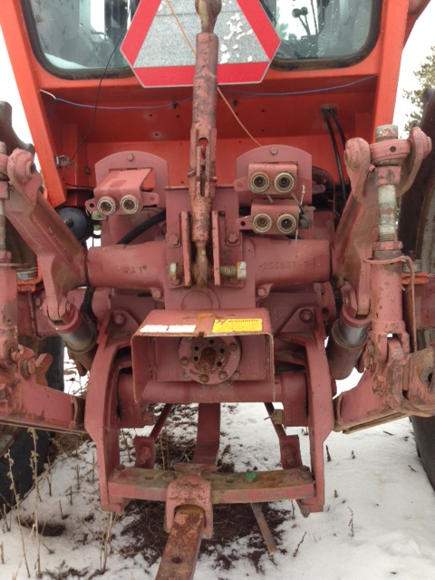 1987 Ford F-250 - The rear of a red tractor is shown, its hitch system and hydraulic connections.