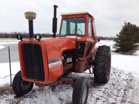 1987 Ford F-250 - An orange Allis-Chalmers AG 7000 tractor sits in a snowy field, with a prominent grille and cab.
