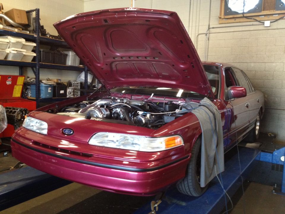 Maroon 1992 Ford Crown Victoria with hood open, showing engine and turbocharger, on a dynamometer
