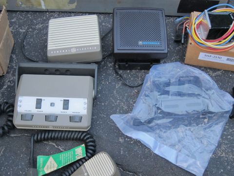 1991 Ford LTD Crown Victoria - Various pieces of radio equipment, including speakers and a control unit, are laid out on asphalt.