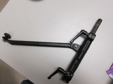 1991 Ford LTD Crown Victoria - A black metal tool with adjustable arms and knobs is shown on a white surface.