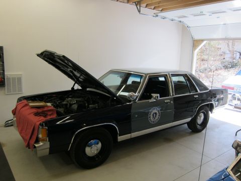 1991 Ford LTD Crown Victoria - 1991 Ford Crown Victoria LTD police car in a garage with its hood open, showing the engine bay.