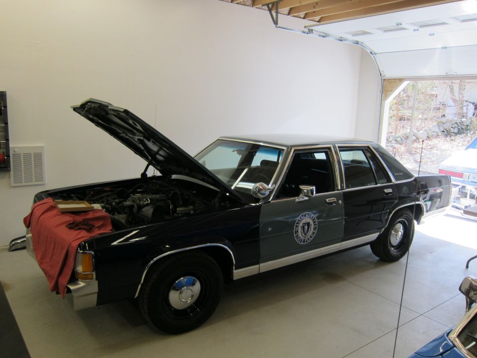 1991 Ford Crown Victoria LTD police car, front quarter view, hood open, dark blue and gray