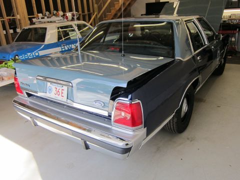 1991 Ford LTD Crown Victoria - A 1991 Ford Crown Victoria LTD police car is seen from the rear, with another police car in the background.