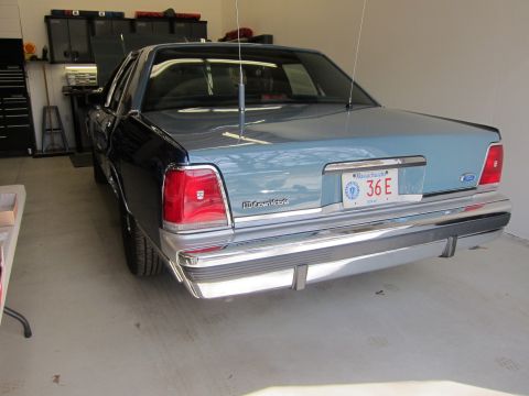 1991 Ford LTD Crown Victoria - Rear view of a 1990s Ford Crown Victoria, showing its distinctive taillights and chrome bumper.