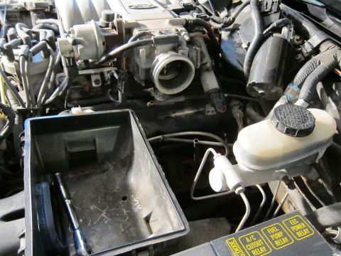 1991 Ford LTD Crown Victoria - Close-up of a vehicle's engine bay, focusing on the air intake system and brake fluid reservoir.