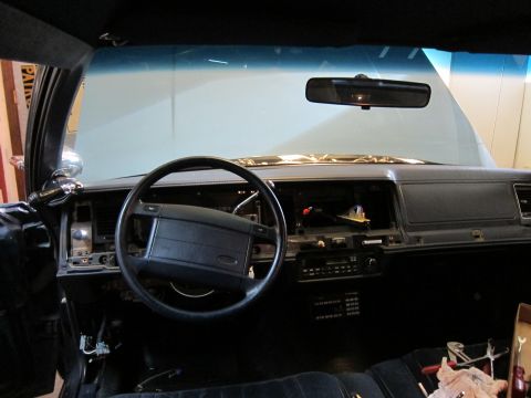 1991 Ford LTD Crown Victoria - The interior of a car shows a disassembled dashboard, steering wheel, and center console area.