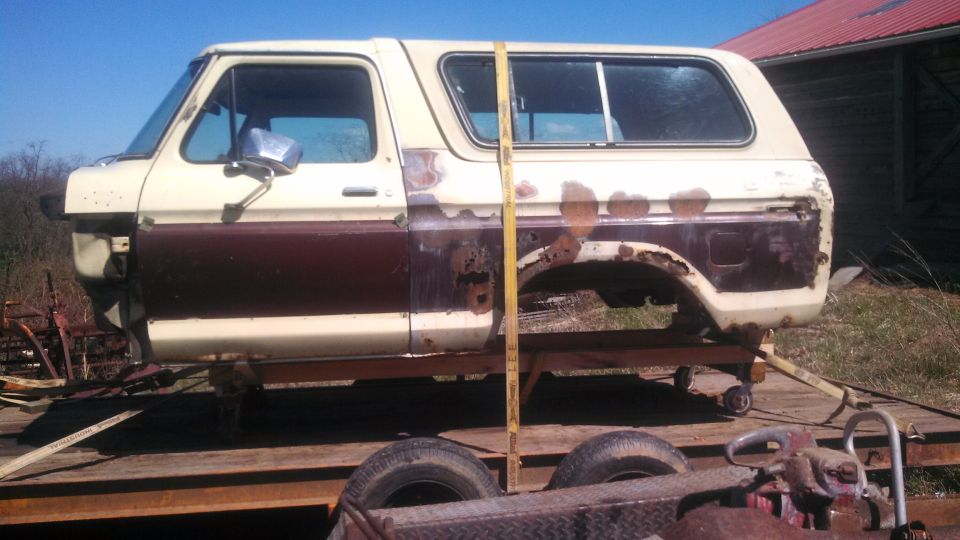 Side view of a 1979 Ford Bronco body, tan and brown, on a trailer