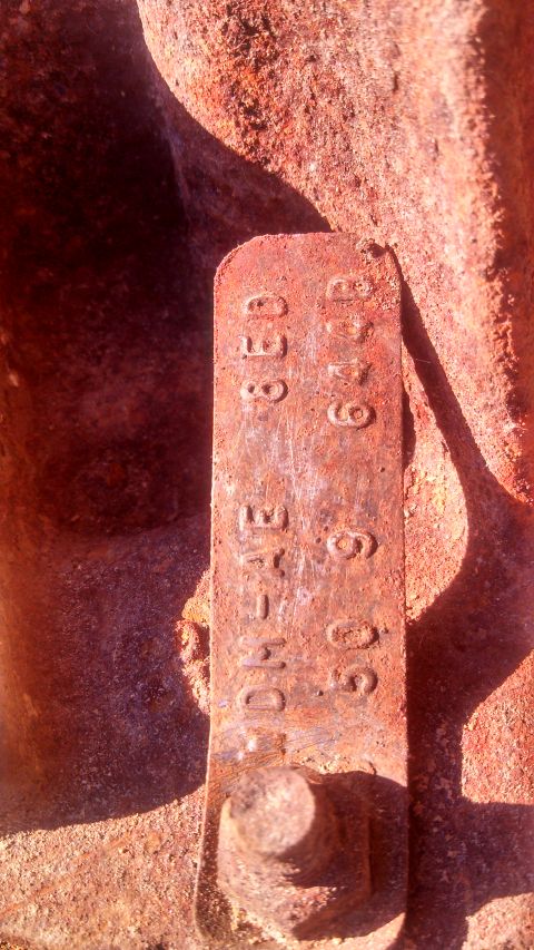 1979 Ford Bronco - Close-up of a rusty metal part with stamped identification numbers.