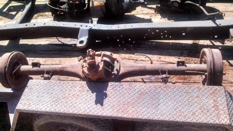 1979 Ford Bronco - A rusty rear axle assembly, likely from a truck or SUV, is shown disassembled from a vehicle.