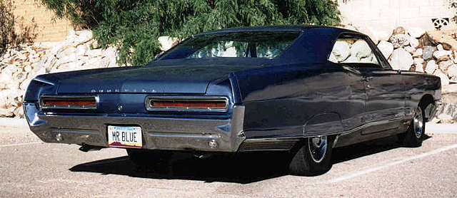 Blue sedan rear view with 'MR BLUE' license plate
