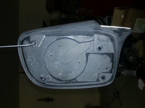 1994 Ford Bronco - The reverse side of a vehicle's side mirror assembly, showing internal mounting points and wiring access.