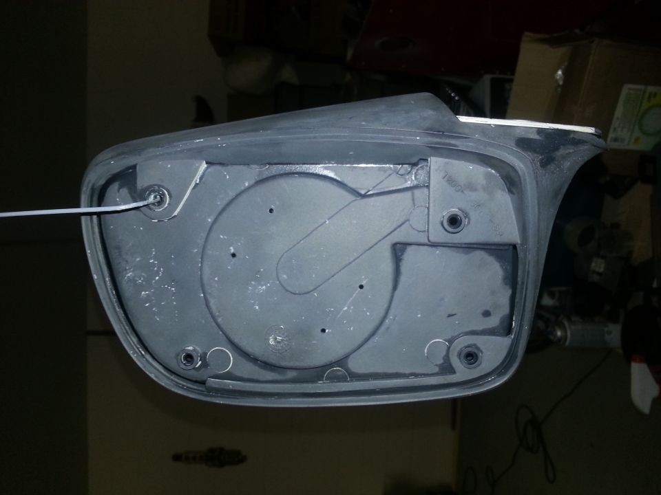 Back of gray side mirror assembly with mounting bracket and wire
