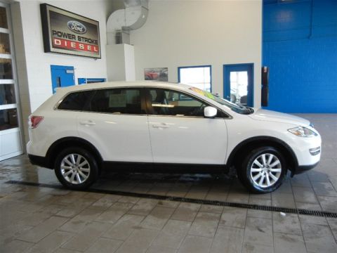 2008 Mazda CX-9 - A white 2008 Mazda CX-9 is shown from the side in a showroom with a Ford Power Stroke Diesel sign in the background.