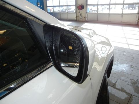2008 Mazda CX-9 - Side view of a white SUV's exterior mirror, reflecting the garage environment.