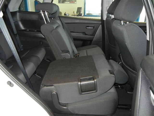Back seats of a car, showing folded-down armrest and seatbelts