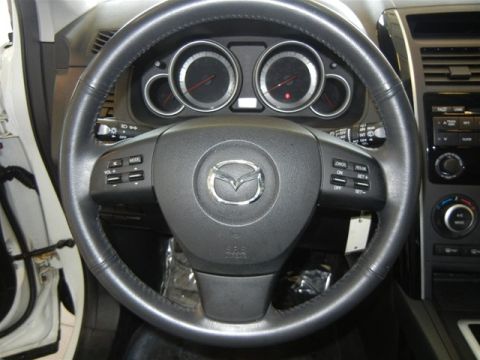 2008 Mazda CX-9 - Interior view of a 2008 Mazda CX-9, showing the steering wheel, instrument cluster, and center console.