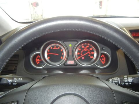 2008 Mazda CX-9 - The interior dashboard of a 2008 Mazda CX-9 displays illuminated gauges and the steering wheel.