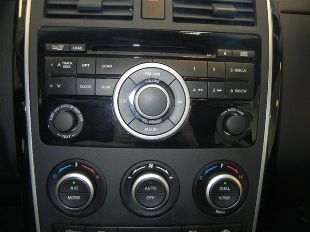 Black dashboard interior of a 2008 Mazda CX-9 showing the center console with radio and climate controls