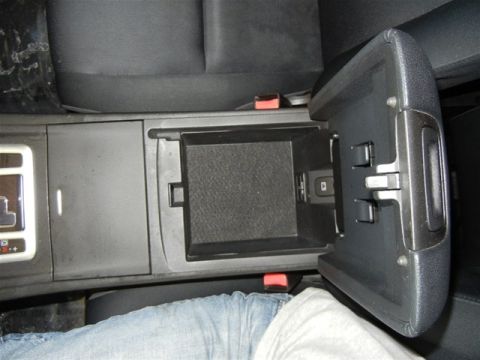 2008 Mazda CX-9 - The interior of a vehicle shows an open armrest storage compartment with a USB port.