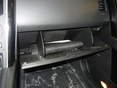 2008 Mazda CX-9 - Interior view of a vehicle's glove box compartment, showing its contents.