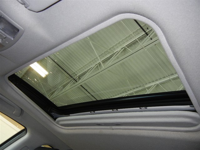 Car interior sunroof open, showing ceiling structure above