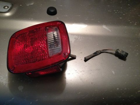 2005 Jeep Wrangler - A detached taillight assembly and its wiring harness are shown, likely removed for repair or replacement.