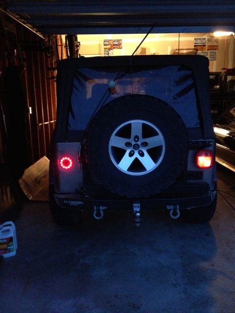 2005 Jeep Wrangler - This Jeep Wrangler is parked in a garage, showing its rear end with a spare tire and custom bumper.