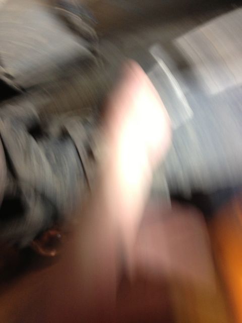 2005 Jeep Wrangler - The interior of a vehicle is captured in a blurry photograph, showing a hand and website text.