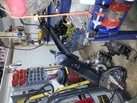 1991 Ford Festiva - A disassembled rear axle assembly is shown, likely for a small car, with various tools and parts in the background.