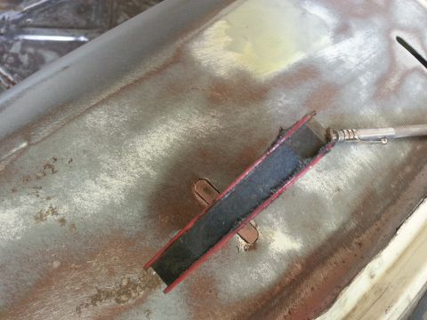 1967 Ford F-100 - A tool is used to clean a rusty metal panel, likely part of a vehicle body restoration.