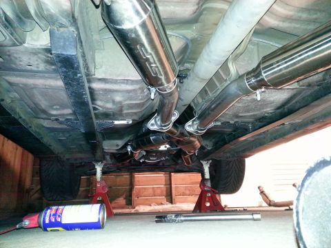 1995 Ford Mustang - The underside of a vehicle shows a custom exhaust system, including Magnaflow mufflers and an X-pipe configuration.