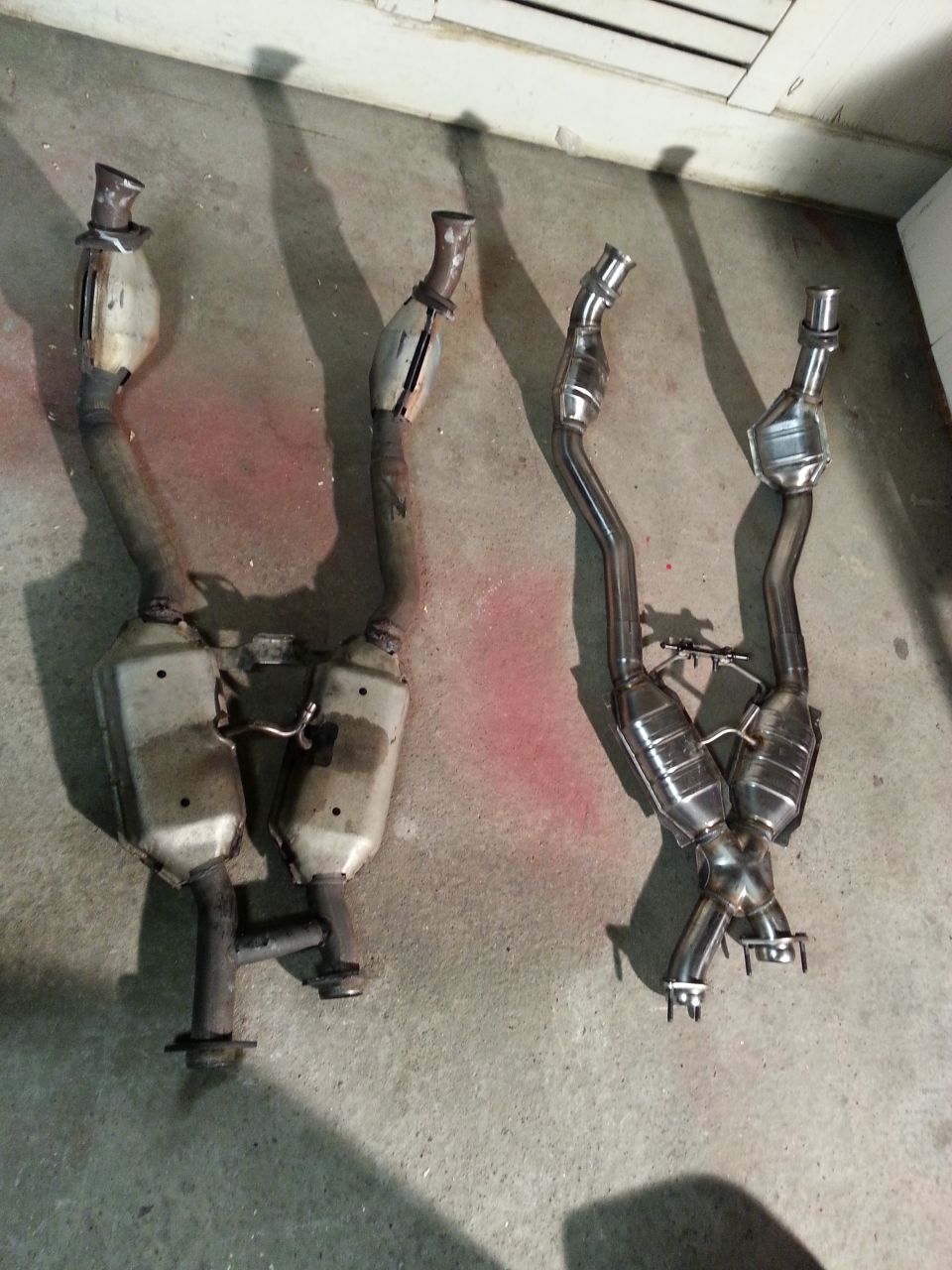 Two exhaust systems with catalytic converters on a concrete floor